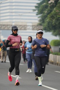 9 Haziran 2024 'te Endonezya' nın Jakarta kenti: Sudirman - Thamrin, Merkez Jakarta 'da sabah saatlerinde Arabasız Günü' nde egzersiz yapan Asyalı insanlar. Seçici odaklanma. Odaklanamadı