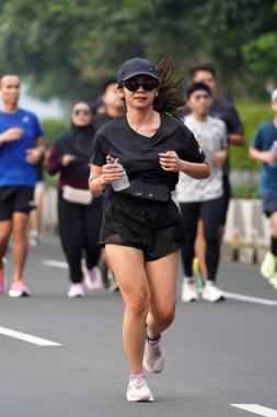 9 Haziran 2024 'te Endonezya' nın Jakarta kenti: Sudirman - Thamrin, Merkez Jakarta 'da sabah saatlerinde Arabasız Günü' nde egzersiz yapan Asyalı insanlar. Seçici odaklanma. Odaklanamadı