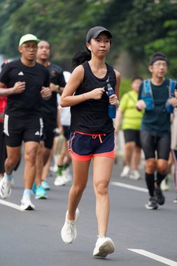 9 Haziran 2024 'te Endonezya' nın Jakarta kenti: Sudirman - Thamrin, Merkez Jakarta 'da sabah saatlerinde Arabasız Günü' nde egzersiz yapan Asyalı insanlar. Seçici odaklanma. Odaklanamadı