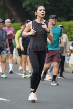 9 Haziran 2024 'te Endonezya' nın Jakarta kenti: Sudirman - Thamrin, Merkez Jakarta 'da sabah saatlerinde Arabasız Günü' nde egzersiz yapan Asyalı insanlar. Seçici odaklanma. Odaklanamadı