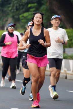 9 Haziran 2024 'te Endonezya' nın Jakarta kenti: Sudirman - Thamrin, Merkez Jakarta 'da sabah saatlerinde Arabasız Günü' nde egzersiz yapan Asyalı insanlar. Seçici odaklanma. Odaklanamadı