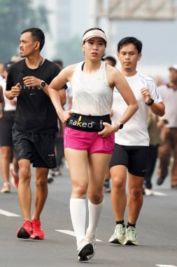 9 Haziran 2024 'te Endonezya' nın Jakarta kenti: Sudirman - Thamrin, Merkez Jakarta 'da sabah saatlerinde Arabasız Günü' nde egzersiz yapan Asyalı insanlar. Seçici odaklanma. Odaklanamadı