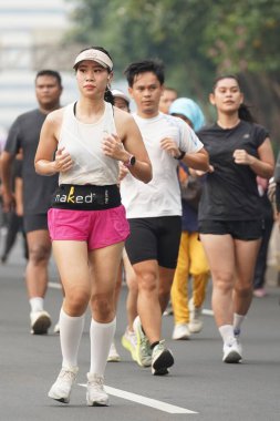 9 Haziran 2024 'te Endonezya' nın Jakarta kenti: Sudirman - Thamrin, Merkez Jakarta 'da sabah saatlerinde Arabasız Günü' nde egzersiz yapan Asyalı insanlar. Seçici odaklanma. Odaklanamadı