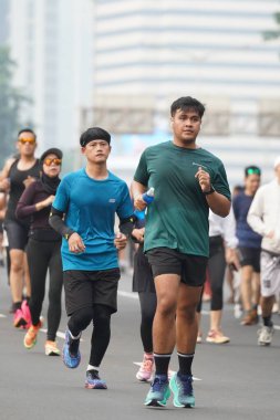 9 Haziran 2024 'te Endonezya' nın Jakarta kenti: Sudirman - Thamrin, Merkez Jakarta 'da sabah saatlerinde Arabasız Günü' nde egzersiz yapan Asyalı insanlar. Seçici odaklanma. Odaklanamadı