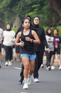 9 Haziran 2024 'te Endonezya' nın Jakarta kenti: Sudirman - Thamrin, Merkez Jakarta 'da sabah saatlerinde Arabasız Günü' nde egzersiz yapan Asyalı insanlar. Seçici odaklanma. Odaklanamadı
