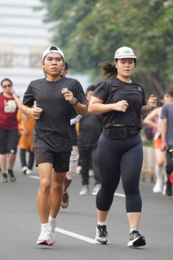 9 Haziran 2024 'te Endonezya' nın Jakarta kenti: Sudirman - Thamrin, Merkez Jakarta 'da sabah saatlerinde Arabasız Günü' nde egzersiz yapan Asyalı insanlar. Seçici odaklanma. Odaklanamadı