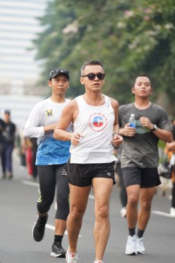 9 Haziran 2024 'te Endonezya' nın Jakarta kenti: Sudirman - Thamrin, Merkez Jakarta 'da sabah saatlerinde Arabasız Günü' nde egzersiz yapan Asyalı insanlar. Seçici odaklanma. Odaklanamadı