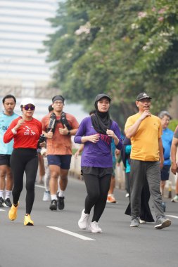 9 Haziran 2024 'te Endonezya' nın Jakarta kenti: Sudirman - Thamrin, Merkez Jakarta 'da sabah saatlerinde Arabasız Günü' nde egzersiz yapan Asyalı insanlar. Seçici odaklanma. Odaklanamadı