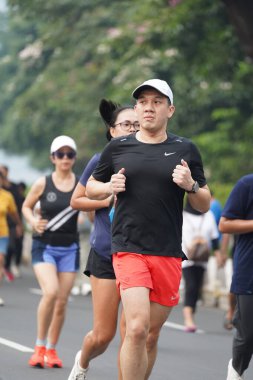 9 Haziran 2024 'te Endonezya' nın Jakarta kenti: Sudirman - Thamrin, Merkez Jakarta 'da sabah saatlerinde Arabasız Günü' nde egzersiz yapan Asyalı insanlar. Seçici odaklanma. Odaklanamadı
