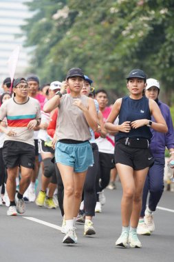 9 Haziran 2024 'te Endonezya' nın Jakarta kenti: Sudirman - Thamrin, Merkez Jakarta 'da sabah saatlerinde Arabasız Günü' nde egzersiz yapan Asyalı insanlar. Seçici odaklanma. Odaklanamadı