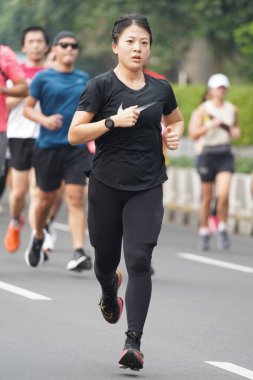 9 Haziran 2024 'te Endonezya' nın Jakarta kenti: Sudirman - Thamrin, Merkez Jakarta 'da sabah saatlerinde Arabasız Günü' nde egzersiz yapan Asyalı insanlar. Seçici odaklanma. Odaklanamadı