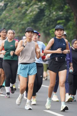 9 Haziran 2024 'te Endonezya' nın Jakarta kenti: Sudirman - Thamrin, Merkez Jakarta 'da sabah saatlerinde Arabasız Günü' nde egzersiz yapan Asyalı insanlar. Seçici odaklanma. Odaklanamadı