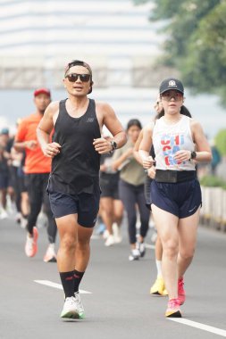 9 Haziran 2024 'te Endonezya' nın Jakarta kenti: Sudirman - Thamrin, Merkez Jakarta 'da sabah saatlerinde Arabasız Günü' nde egzersiz yapan Asyalı insanlar. Seçici odaklanma. Odaklanamadı
