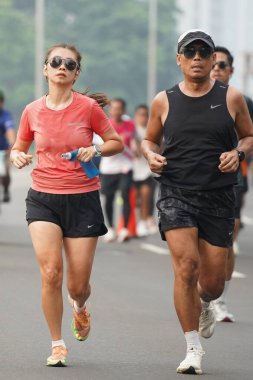 9 Haziran 2024 'te Endonezya' nın Jakarta kenti: Sudirman - Thamrin, Merkez Jakarta 'da sabah saatlerinde Arabasız Günü' nde egzersiz yapan Asyalı insanlar. Seçici odaklanma. Odaklanamadı