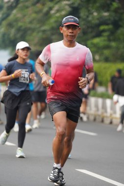 9 Haziran 2024 'te Endonezya' nın Jakarta kenti: Sudirman - Thamrin, Merkez Jakarta 'da sabah saatlerinde Arabasız Günü' nde egzersiz yapan Asyalı insanlar. Seçici odaklanma. Odaklanamadı