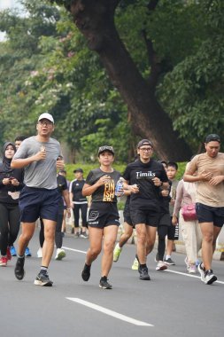 9 Haziran 2024 'te Endonezya' nın Jakarta kenti: Sudirman - Thamrin, Merkez Jakarta 'da sabah saatlerinde Arabasız Günü' nde egzersiz yapan Asyalı insanlar. Seçici odaklanma. Odaklanamadı