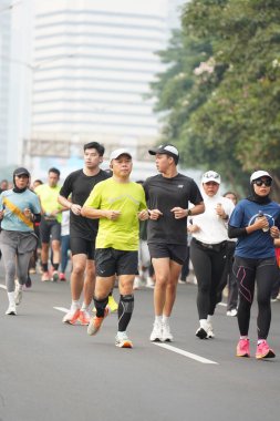 9 Haziran 2024 'te Endonezya' nın Jakarta kenti: Sudirman - Thamrin, Merkez Jakarta 'da sabah saatlerinde Arabasız Günü' nde egzersiz yapan Asyalı insanlar. Seçici odaklanma. Odaklanamadı