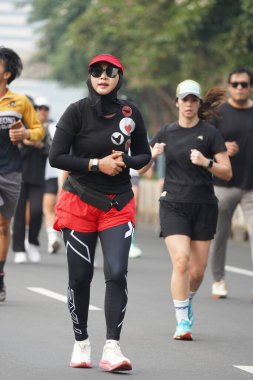 9 Haziran 2024 'te Endonezya' nın Jakarta kenti: Sudirman - Thamrin, Merkez Jakarta 'da sabah saatlerinde Arabasız Günü' nde egzersiz yapan Asyalı insanlar. Seçici odaklanma. Odaklanamadı