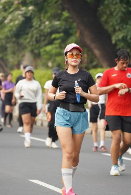 9 Haziran 2024 'te Endonezya' nın Jakarta kenti: Sudirman - Thamrin, Merkez Jakarta 'da sabah saatlerinde Arabasız Günü' nde egzersiz yapan Asyalı insanlar. Seçici odaklanma. Odaklanamadı