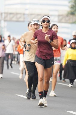 9 Haziran 2024 'te Endonezya' nın Jakarta kenti: Sudirman - Thamrin, Merkez Jakarta 'da sabah saatlerinde Arabasız Günü' nde egzersiz yapan Asyalı insanlar. Seçici odaklanma. Odaklanamadı