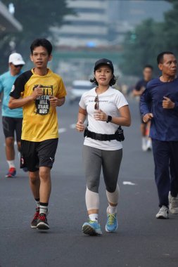 Jakarta, Endonezya 'da 12 Haziran 2024: Asyalılar Orta Jakarta' daki Sudirman-Thamrin bölgesinde koşuyorlar. Arabasız gün Sudirman - Thamrin. Odaklanamadı