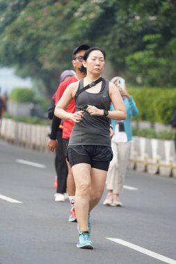 Jakarta, Endonezya 'da 12 Haziran 2024: Asyalılar Orta Jakarta' daki Sudirman-Thamrin bölgesinde koşuyorlar. Arabasız gün Sudirman - Thamrin. Odaklanamadı