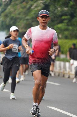 Jakarta, Endonezya 'da 12 Haziran 2024: Asyalılar Orta Jakarta' daki Sudirman-Thamrin bölgesinde koşuyorlar. Arabasız gün Sudirman - Thamrin. Odaklanamadı