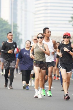 Jakarta, Endonezya 'da 12 Haziran 2024: Asyalılar Orta Jakarta' daki Sudirman-Thamrin bölgesinde koşuyorlar. Arabasız gün Sudirman - Thamrin. Odaklanamadı
