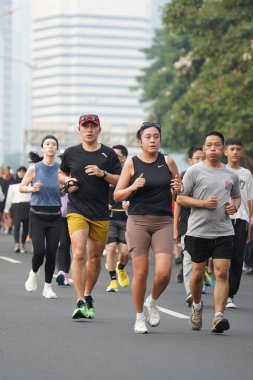 Jakarta, Endonezya 'da 12 Haziran 2024: Asyalılar Orta Jakarta' daki Sudirman-Thamrin bölgesinde koşuyorlar. Arabasız gün Sudirman - Thamrin. Odaklanamadı