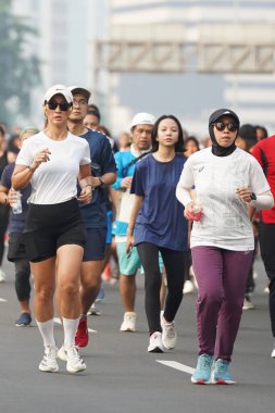 Jakarta, Endonezya 'da 12 Haziran 2024: Asyalılar Orta Jakarta' daki Sudirman-Thamrin bölgesinde koşuyorlar. Arabasız gün Sudirman - Thamrin. Odaklanamadı
