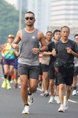 Jakarta, Endonezya 'da 12 Haziran 2024: Asyalılar Orta Jakarta' daki Sudirman-Thamrin bölgesinde koşuyorlar. Arabasız gün Sudirman - Thamrin. Odaklanamadı