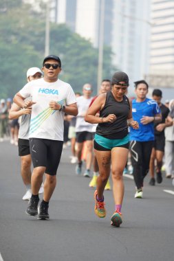 Jakarta, Endonezya 'da 12 Haziran 2024: Asyalılar Orta Jakarta' daki Sudirman-Thamrin bölgesinde koşuyorlar. Arabasız gün Sudirman - Thamrin. Odaklanamadı