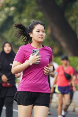 Jakarta, Endonezya 'da 12 Haziran 2024: Asyalılar Orta Jakarta' daki Sudirman-Thamrin bölgesinde koşuyorlar. Arabasız gün Sudirman - Thamrin. Odaklanamadı
