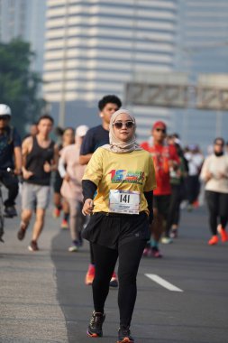 Jakarta, Endonezya 'da 12 Haziran 2024: Asyalılar Orta Jakarta' daki Sudirman-Thamrin bölgesinde koşuyorlar. Arabasız gün Sudirman - Thamrin. Odaklanamadı