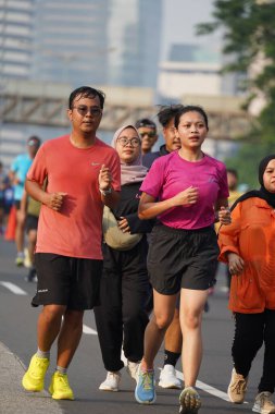 Jakarta, Endonezya 'da 12 Haziran 2024: Asyalılar Orta Jakarta' daki Sudirman-Thamrin bölgesinde koşuyorlar. Arabasız gün Sudirman - Thamrin. Odaklanamadı