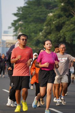 Jakarta, Endonezya 'da 12 Haziran 2024: Asyalılar Orta Jakarta' daki Sudirman-Thamrin bölgesinde koşuyorlar. Arabasız gün Sudirman - Thamrin. Odaklanamadı