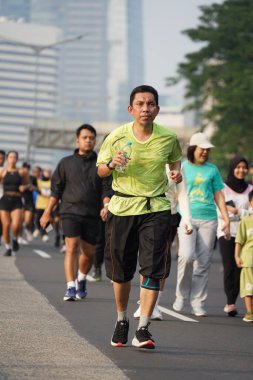 Jakarta, Endonezya 'da 12 Haziran 2024: Asyalılar Orta Jakarta' daki Sudirman-Thamrin bölgesinde koşuyorlar. Arabasız gün Sudirman - Thamrin. Odaklanamadı