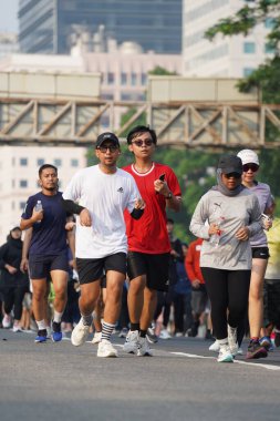 Jakarta, Endonezya 'da 12 Haziran 2024: Asyalılar Orta Jakarta' daki Sudirman-Thamrin bölgesinde koşuyorlar. Arabasız gün Sudirman - Thamrin. Odaklanamadı