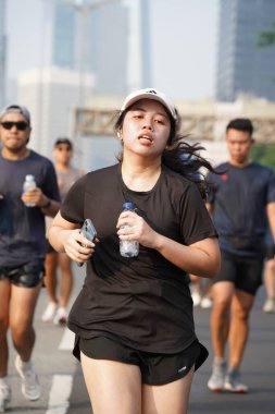Jakarta, Endonezya 'da 12 Haziran 2024: Asyalılar Orta Jakarta' daki Sudirman-Thamrin bölgesinde koşuyorlar. Arabasız gün Sudirman - Thamrin. Odaklanamadı