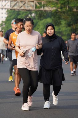 Jakarta, Endonezya 'da 12 Haziran 2024: Asyalılar Orta Jakarta' daki Sudirman-Thamrin bölgesinde koşuyorlar. Arabasız gün Sudirman - Thamrin. Odaklanamadı