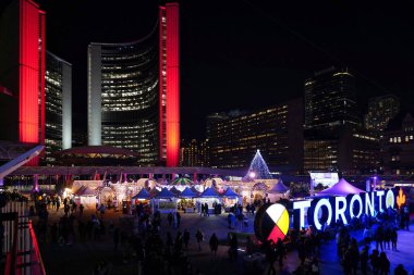 Toronto, Kanada - 4 Aralık 2022 Toronto her yıl belediye binasının önündeki meydanı ışıklar, biniciler ve satıcılarla dolu bir Noel karnavalı ile doldurur..