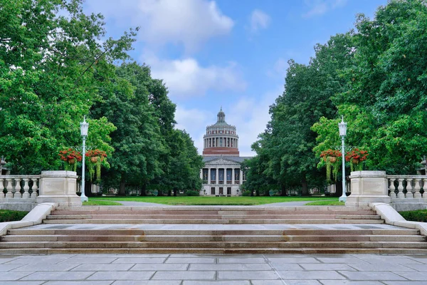 stock image Rochester, NY - August 2022:  Stone steps leading up to the main tree lined courtyard on the campus of the University of Rochester, with the Rush Rhees Library building in the background.