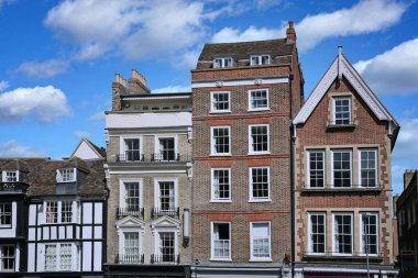 Tepesinde daireler, altında mağazalar olan yüksek, dar eski binalar. Cambridge, İngiltere.