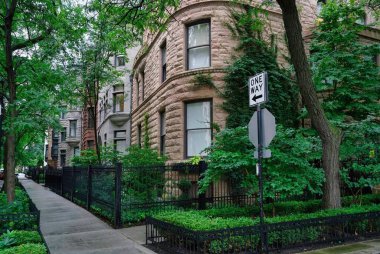 Shady residential street with old stone townhouses and apartment buildings, Chicago Gold Coast area clipart