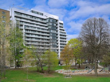 Apartman binaları ve parkta oyun parkı olan şehir manzarası