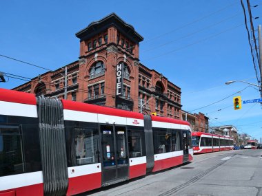 Modern Toronto streetcars in front of a historic 19th century hotel clipart