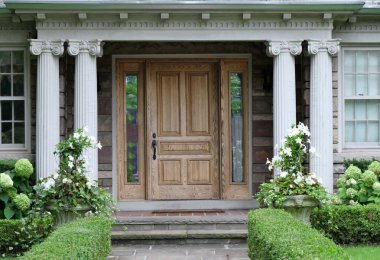Klasik sütunları olan ahşap kapılı bir ev.