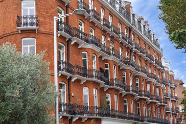 Londra 'nın Chelsea bölgesinde demiryolu döşenmiş demir balkon parmaklıkları olan bir apartman.