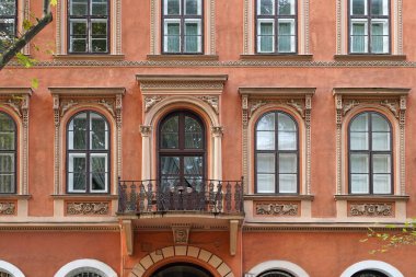 Süslü pencere çerçeveli renkli sıva apartman önü