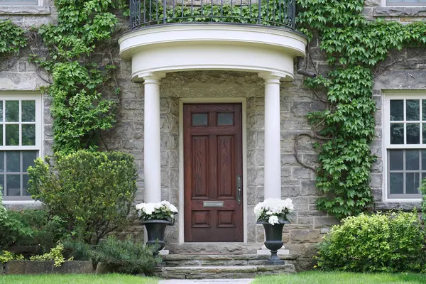 Asmalı ve ahşap kapılı taş evin girişi.
